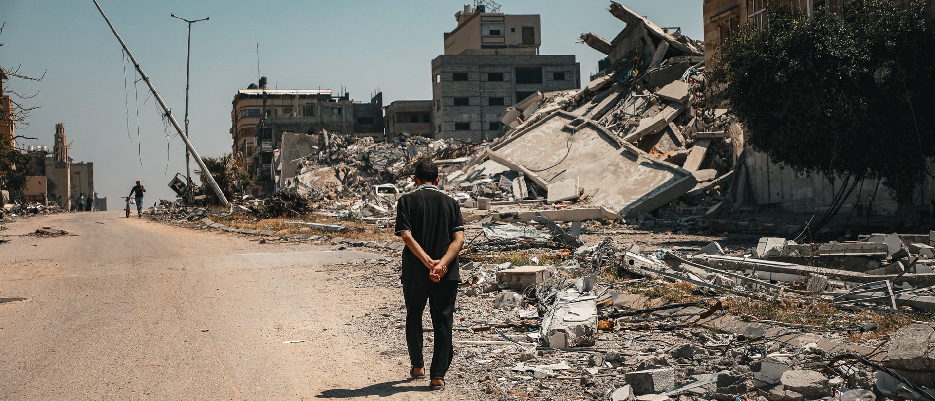 A Man Walks Beside Destroyed Buildings In Gaza Photo Credit Caritas Jerusalem