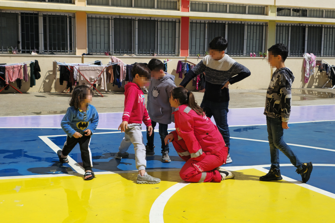 Children with a Caritas Lebanon worker at a collective shelter site photo credit Caritas Lebanon.jpg