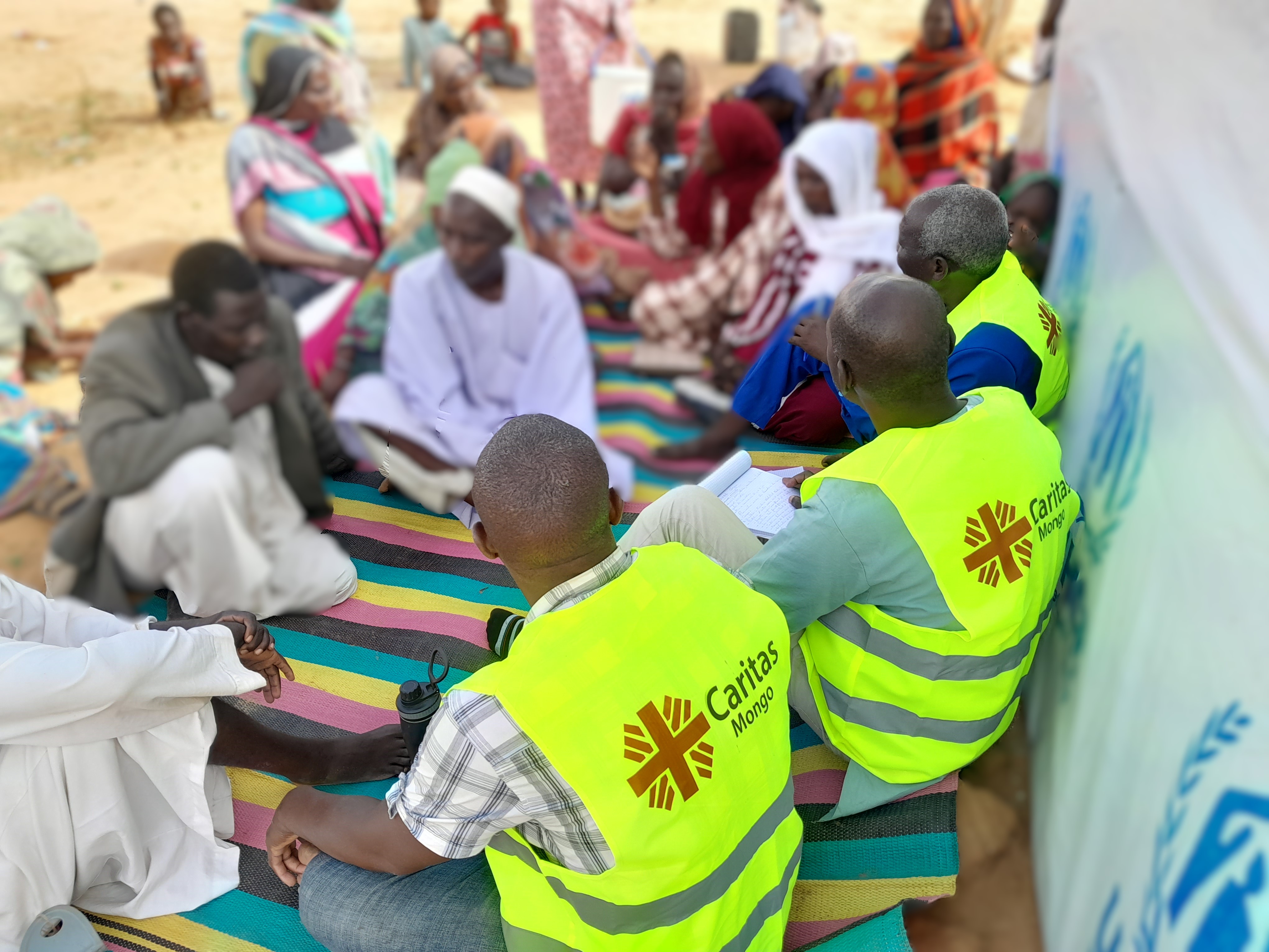 Aid Workers Sit With Sudanese Refugees In Chad Photo Credit Caritas Mongo