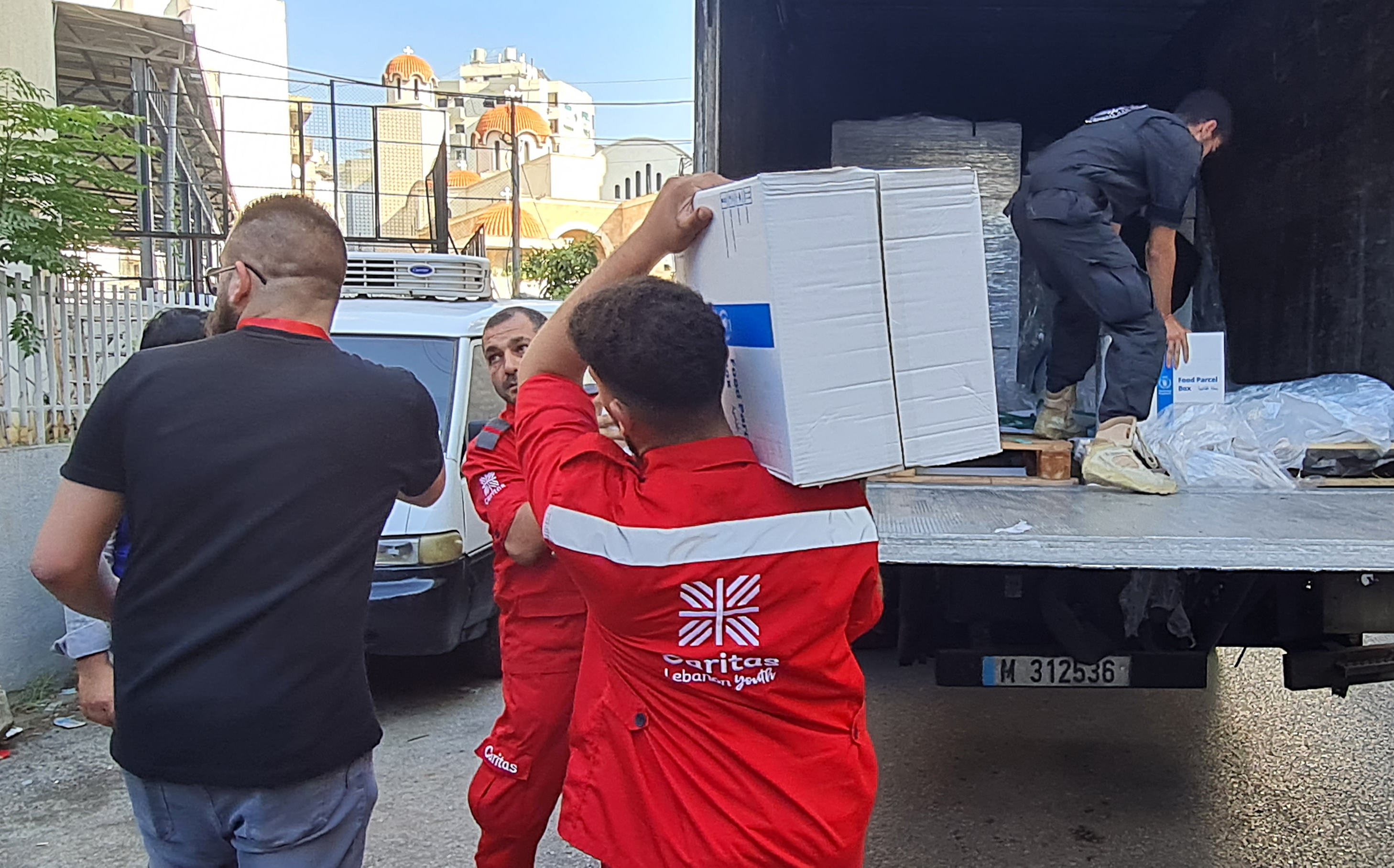 Caritas Lebanon Employees Load Supplies Into A Van Photo Credit Caritas Lebanon