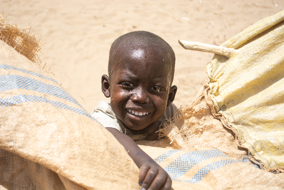 Smiling child in Sudan. Photo credit: George Wambugu/CAFOD