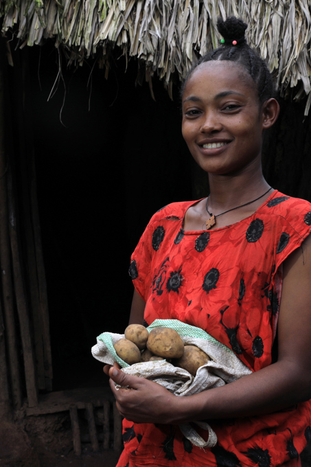 Yeshareg With Potatoes Outside Her Home