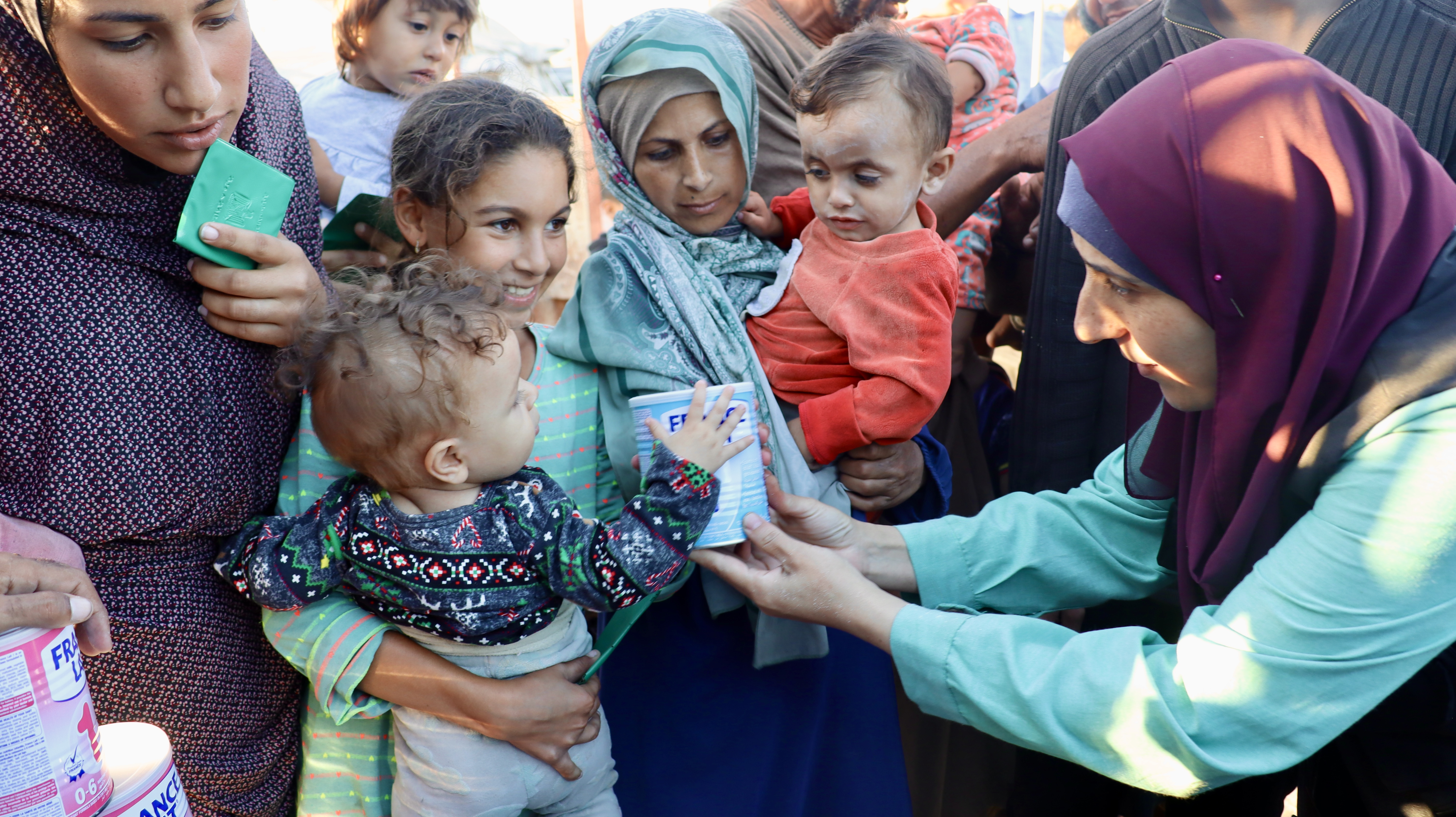 A Baby Grasps At Infant Formula In Khan Younis Refugee Camp Photo Credit Caritras Jerusalem