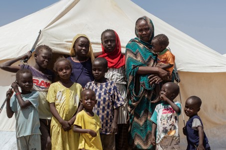 Nadia and her family in front of a camp in Sudan. Photo credit: George Wambugu/CAFOD (1)