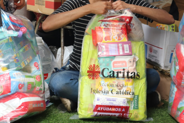 A Woman Opens An Aid Package Being Distributed By Caritas Photo Credit Caritas Venezuela