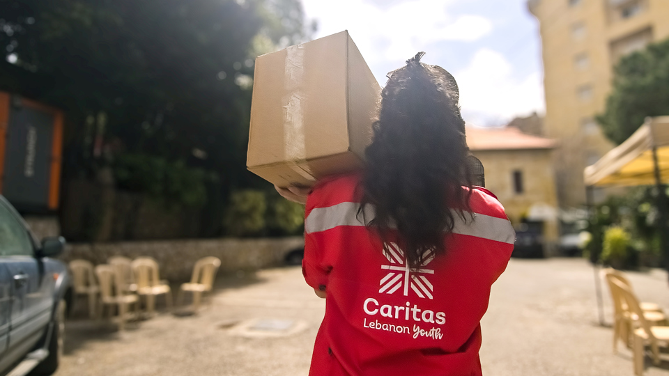A member of Caritas Youth carries a box of aid photo credit Caritas Lebanon.jpg