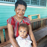 Rose with her baby outside a health centre in PNG. Photo credits Caritas Australia.