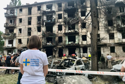 A Caritas Ukraine staff member looks at an apartment block damaged by shelling photo credit Caritas Ukraine.jpg