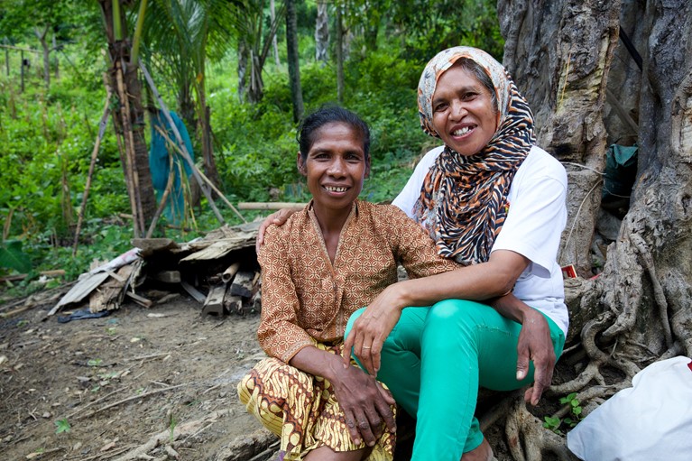 Martina (left) outside her home talking with Domingas Tilman, her councillor from Uma Paz women's refuge in Baucau, Timor-Leste. Photo: Richard Wainwright/Caritas Australia.