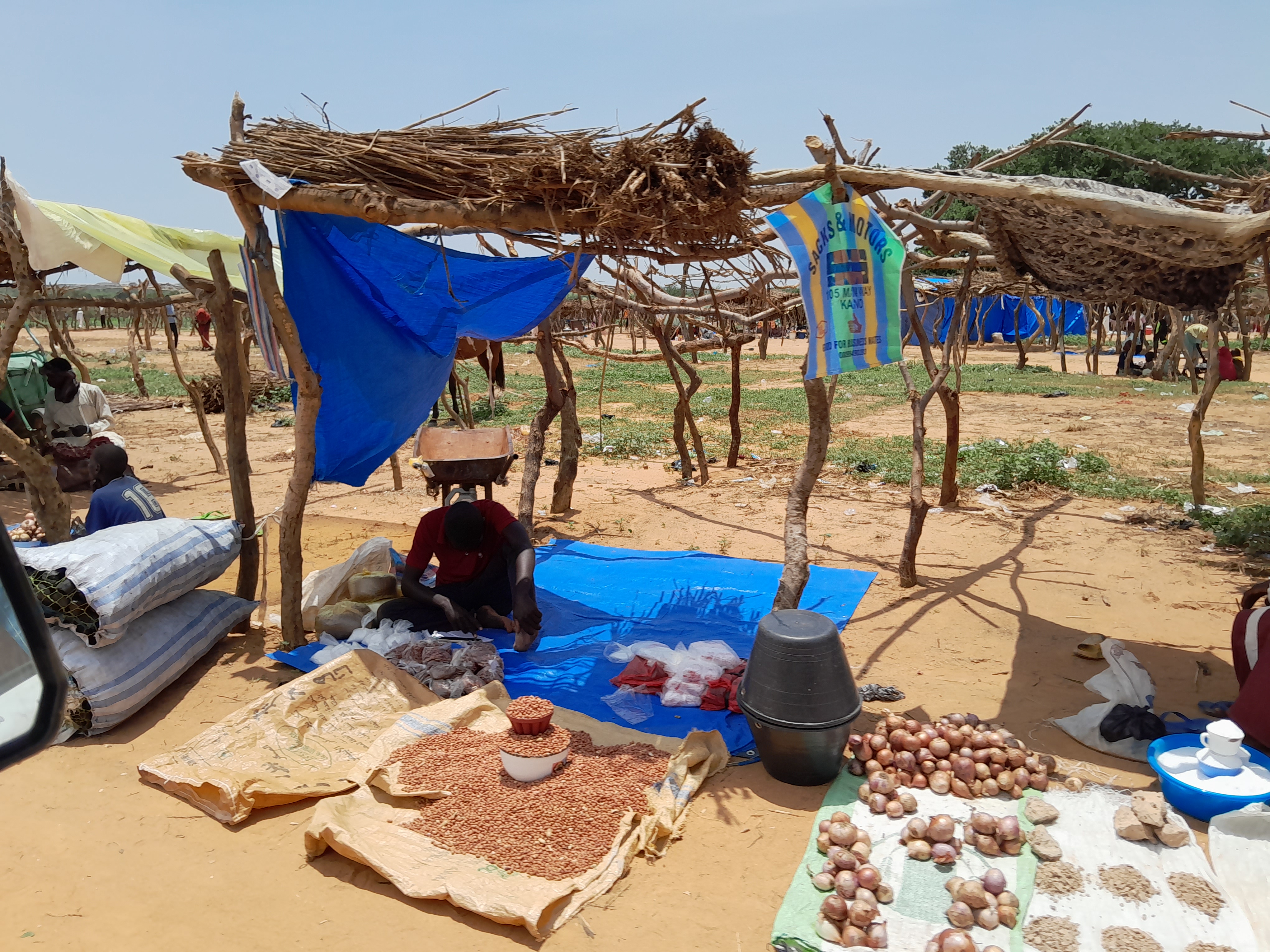 A Man Seeks Shade At A Transit Camp For Sudanese Refugees Receiving Aid Photo Credit Caritas Mongo