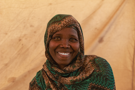 Nadia smiling in a camp. Sudan. Photo credit: George Wambugu/CAFOD