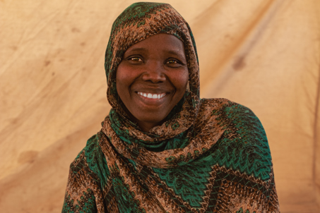 Nadia smiling in a camp. Sudan. Photo credit: George Wambugu/CAFOD