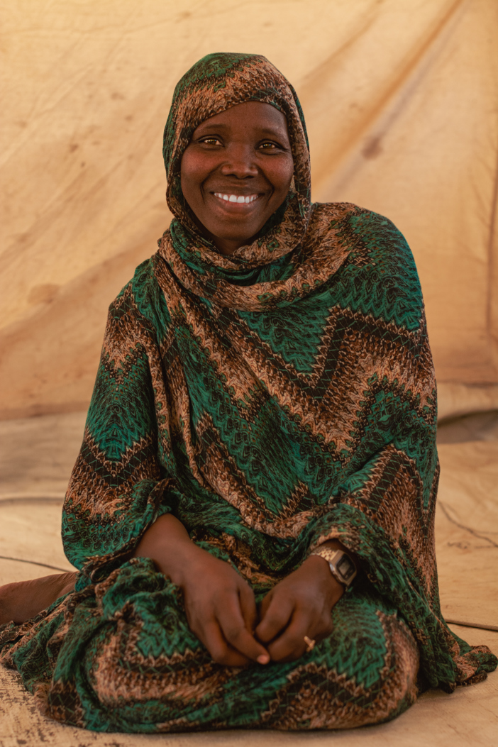 Nadia smiling in a camp. Sudan. Photo credit: George Wambugu/CAFOD