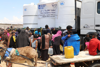Families Fill Containers Of Clean Water As Part Of Water Trucking Services Photo Credit CRS