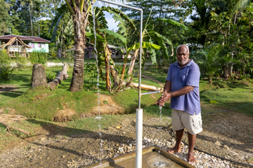 Fr Clement testing out the new water system in his village. Photo: Caritas Australia