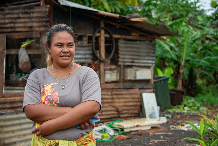 Leaia outside her home in Samoa, which was built from recycled scraps. Photo: Laura Womersley/Caritas Australia