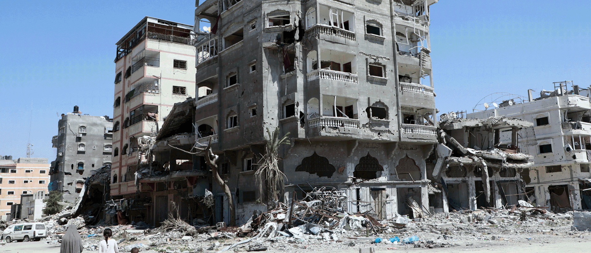 Two Adults And A Child Walk Through Gaza During The Ongoing Devastation