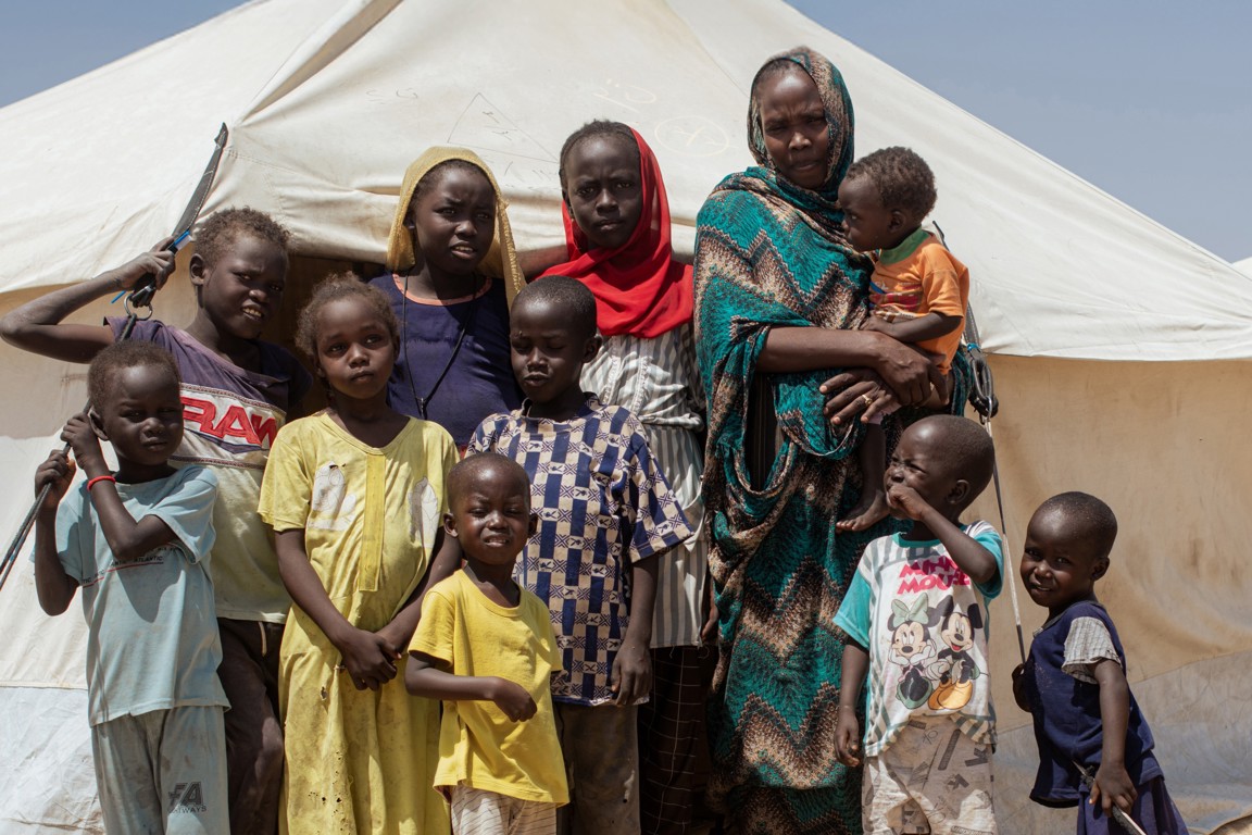 Nadia and her family in front of a camp in Sudan. Photo credit: George Wambugu/CAFOD (2)