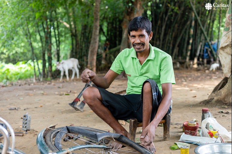 Biru is seen working at his bicycle repair shop outside his home in his village in the state of Jharkhand, India. Photo: Sameer Bara/Caritas Australia