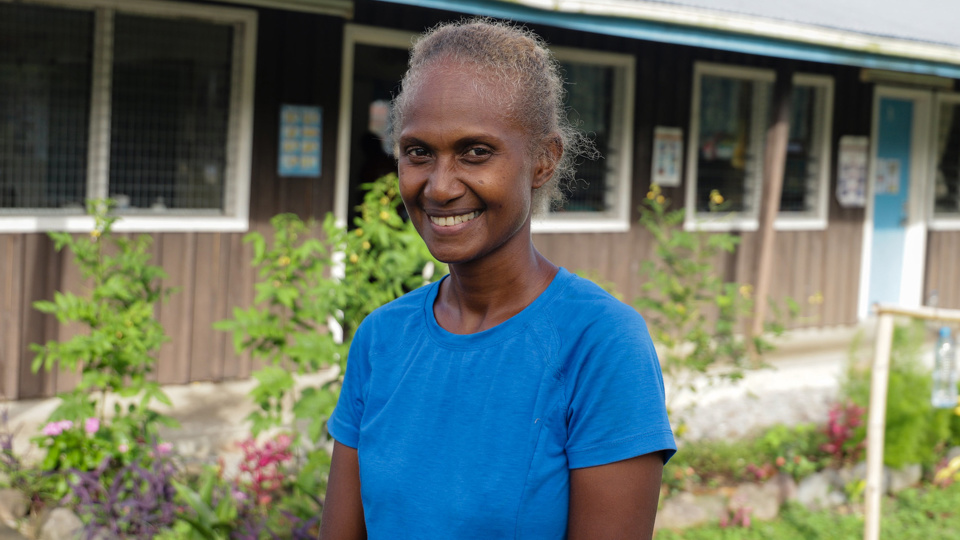 Margret standing outside a school in the Solomon Islands
