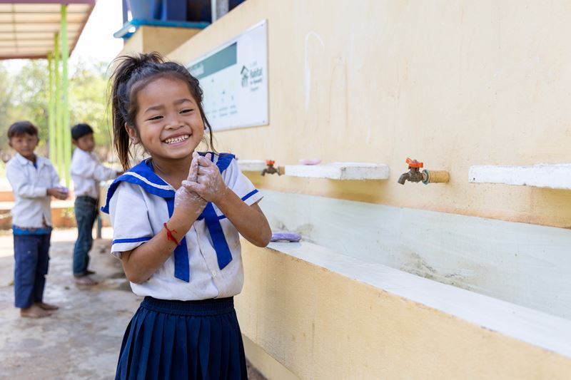 A young girl washing her hands at her school in Cambodia