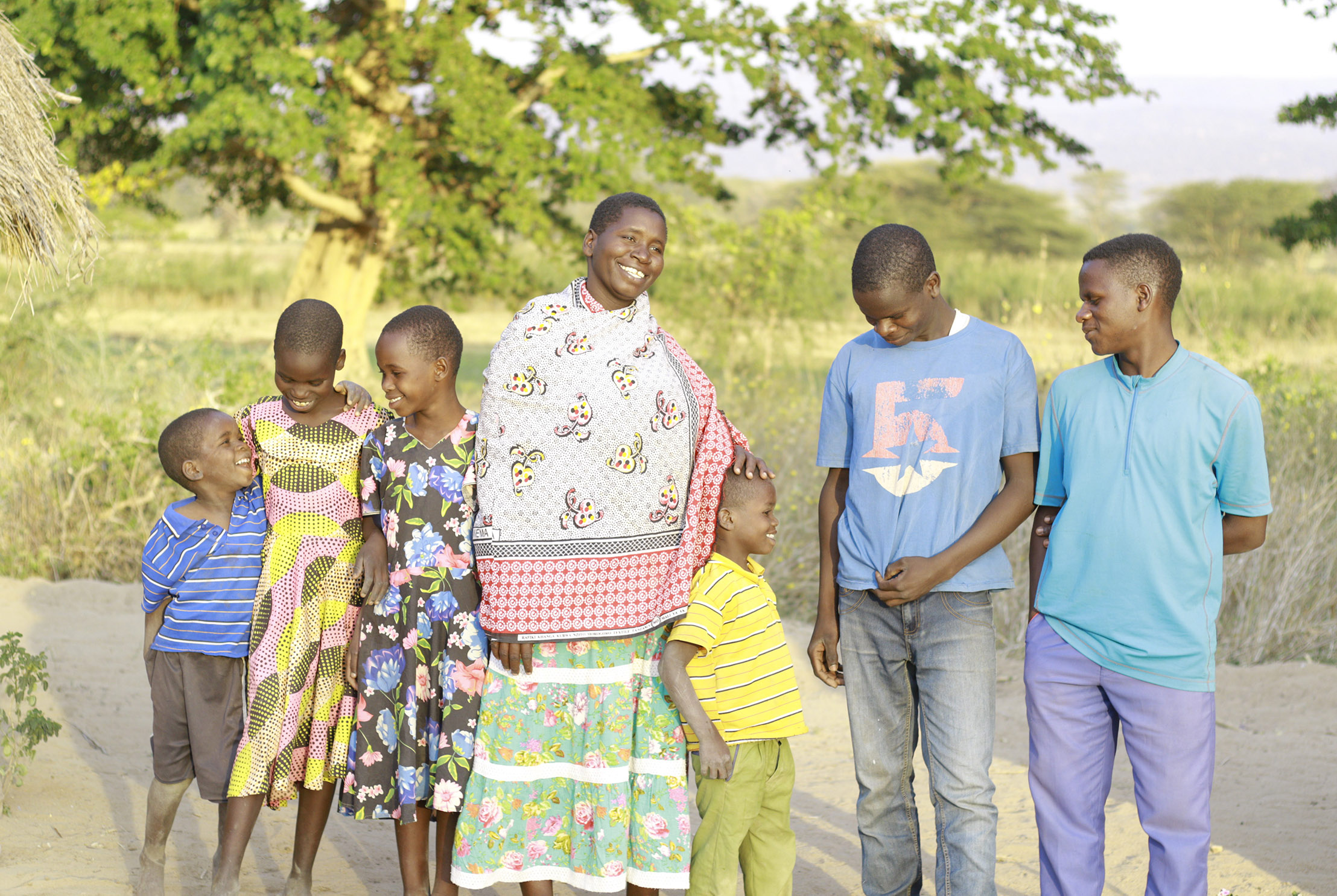 Maria standing with her family outside their home in Tanzania (1)