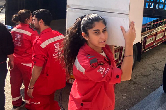 An aid worker carries a box of aid on the 2nd of March photo credit Caritas Lebanon.jpg