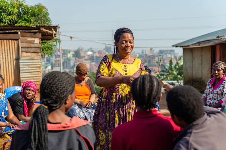 Rosalie (standing) attends a Saving and Internal Lending Community group (SILC) meeting near her home in eastern Democratic Republic of Congo. Rosalie is now the president of this SILC group which provided a loan to start her business. Photo: Arlette Bashizi/Caritas Australia 