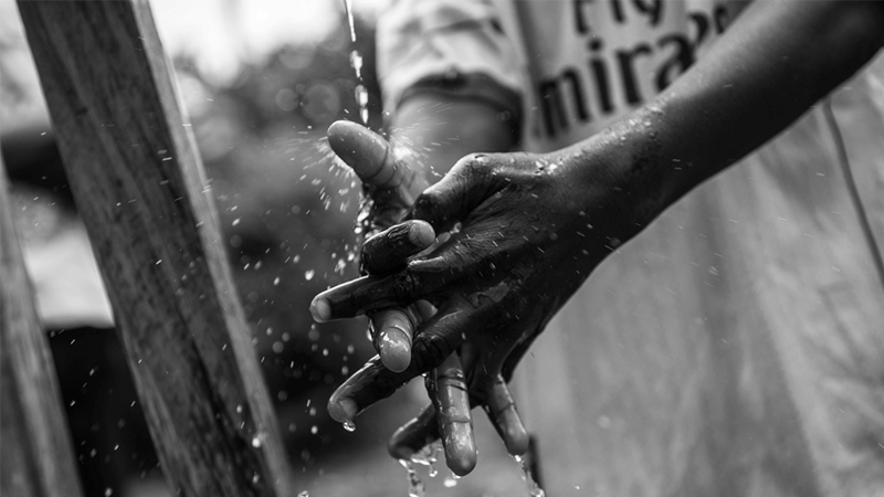 child washing hands in water
