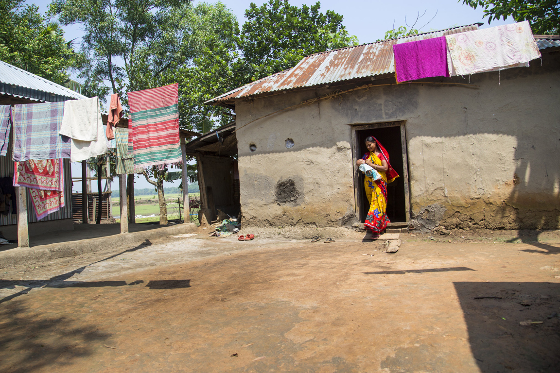 Woman carrying infant in rural Bangladesh