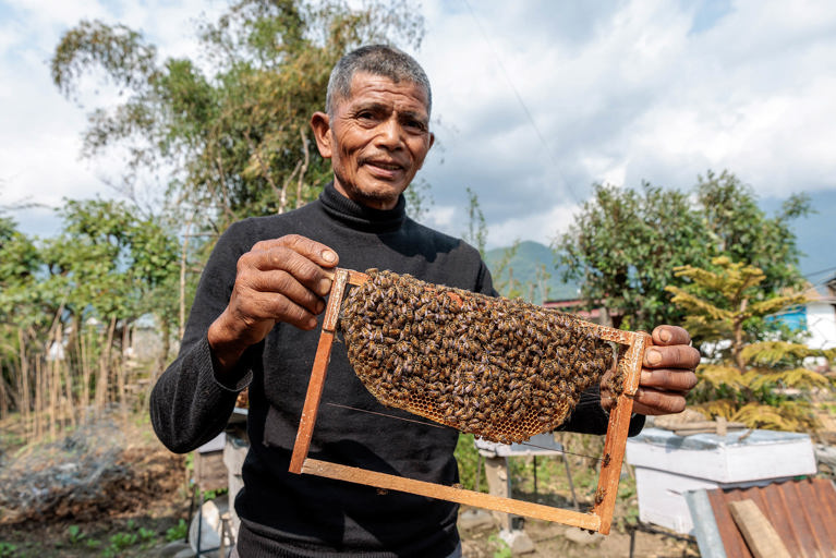 Chandrabahadur is a beekeeper who generates income from selling honey. Photo: Richard Wainwright/Caritas Australia