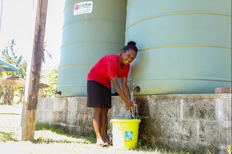 Shaniella collects water from a water tank at her Rural Training Centre near the capital Honiara, Solomon Islands. Photo: Neil Nuia/Caritas Australia
