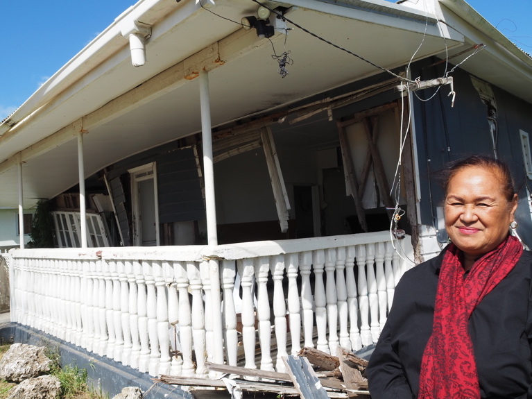 Tupou standing outside a home destroyed by the tsunami in Tonga. Photo: Nicole Chehine/Caritas Australia