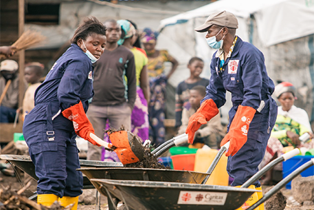 Members of the Hygiene Committee assist with cleaning up the camp site. Photo: Caritas Goma.
