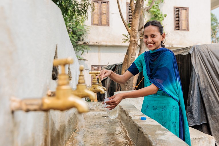 Laxmi using a water tap that she advocated to have installed as a member of the Child Club at her old school in Jajarkot district, western Nepal. Photo: Richard Wainwright/Caritas Australia