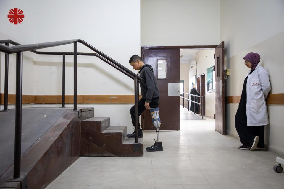 A Young Boy Works On Scaling Stairs With His Artificial Limb Photo Credit Caritas Jerusalem