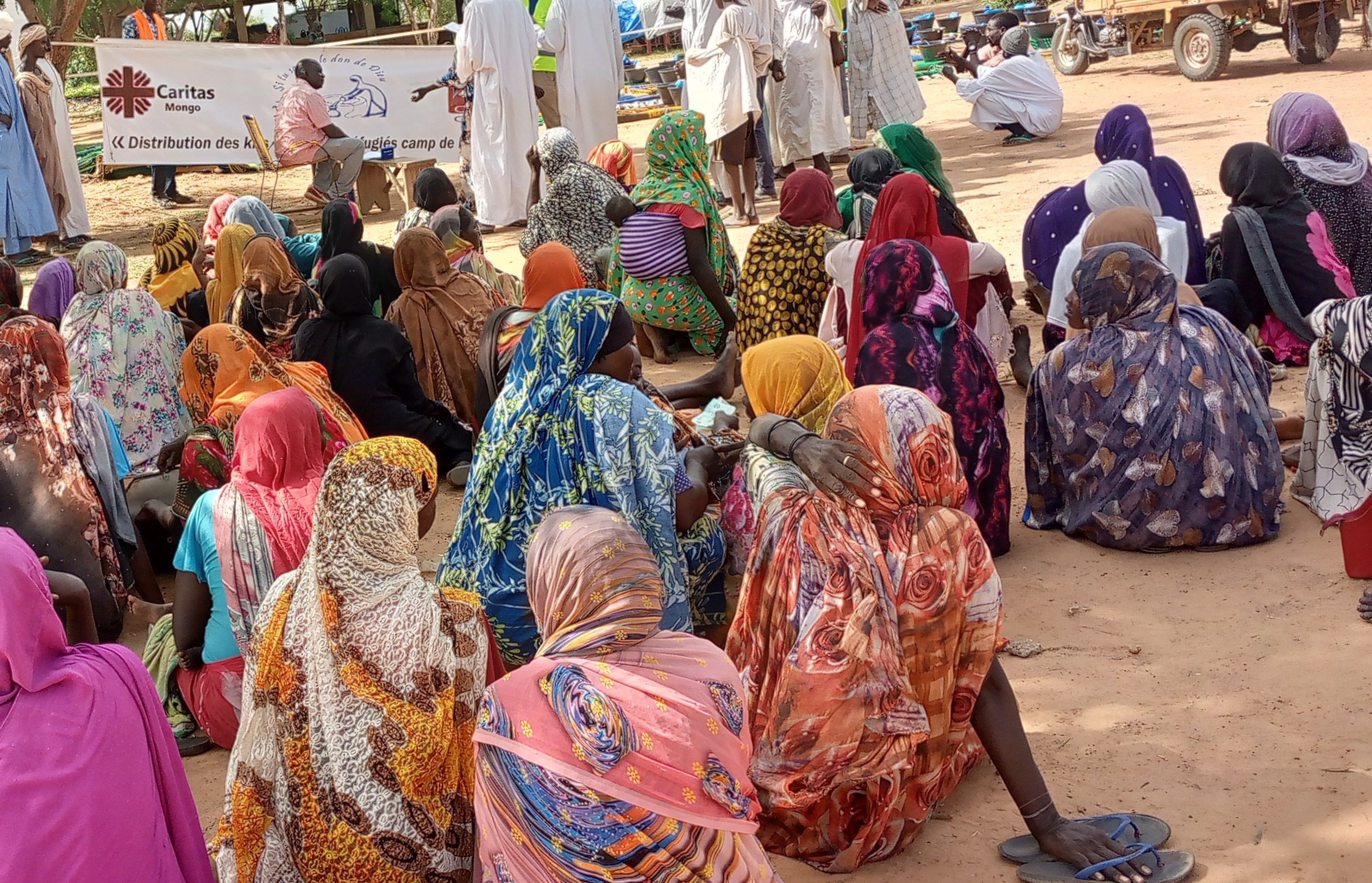 Women And Children Wait To Recieve Aid At A Transit Camp For Sudanese Refugees Photo Credit Caritas Mongo