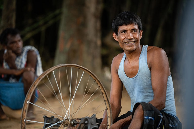 Biru is seen working at his bicycle repair shop outside his home in his village in the state of Jharkhand, India. Photo: Sameer Bara/Caritas Australia