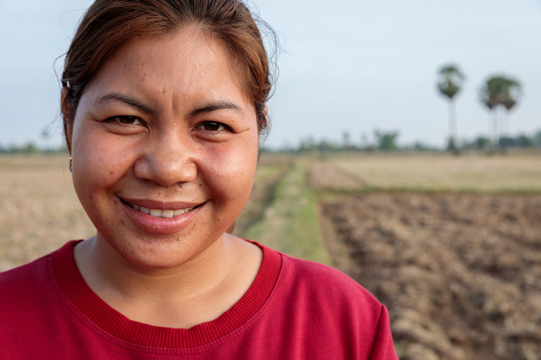 Phany standing in a field in western Cambodia. Photo credit: Richard Wainwright/Caritas Australia.