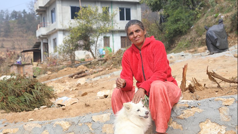 Sita sits with her dog in her village. Credit: Dipendra Lamsal.
