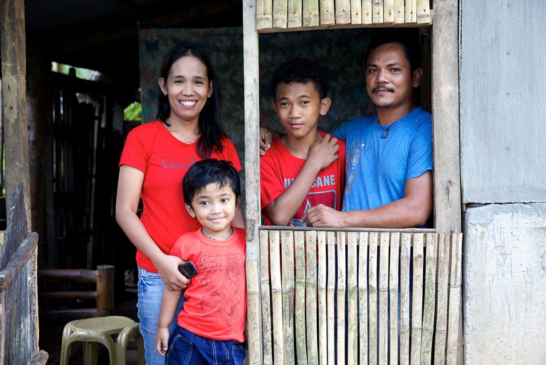 Aloma With Her Family In Their Home In The Philippines. Photo credit: Richard Wainwright/Caritas Australia.