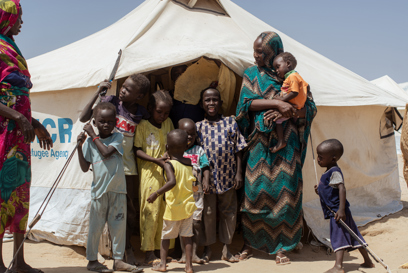 Nadia and her family in front of a camp in Sudan. Photo credit: George Wambugu/CAFOD