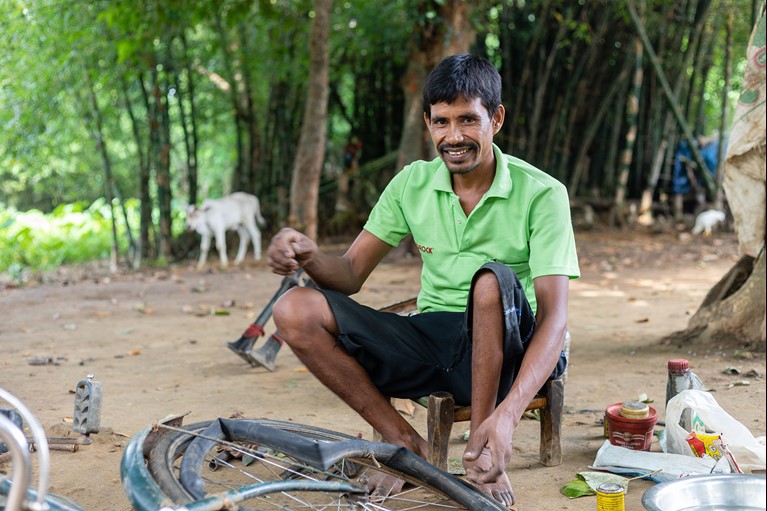 Biru is seen working at his bicycle repair shop outside of his home in India. Photo credit: Sameer Bara/Caritas Australia.