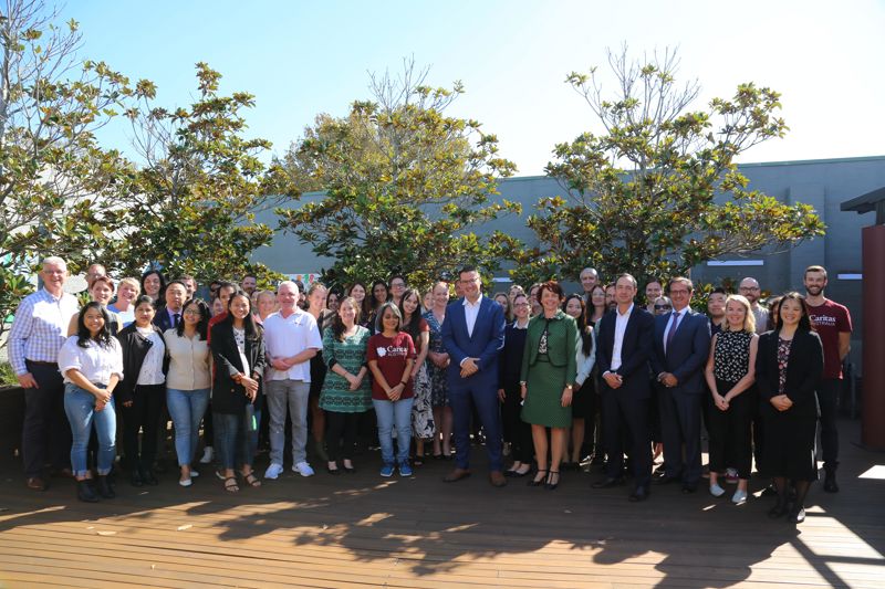 Minister with NGO staff in courtyard in Australia