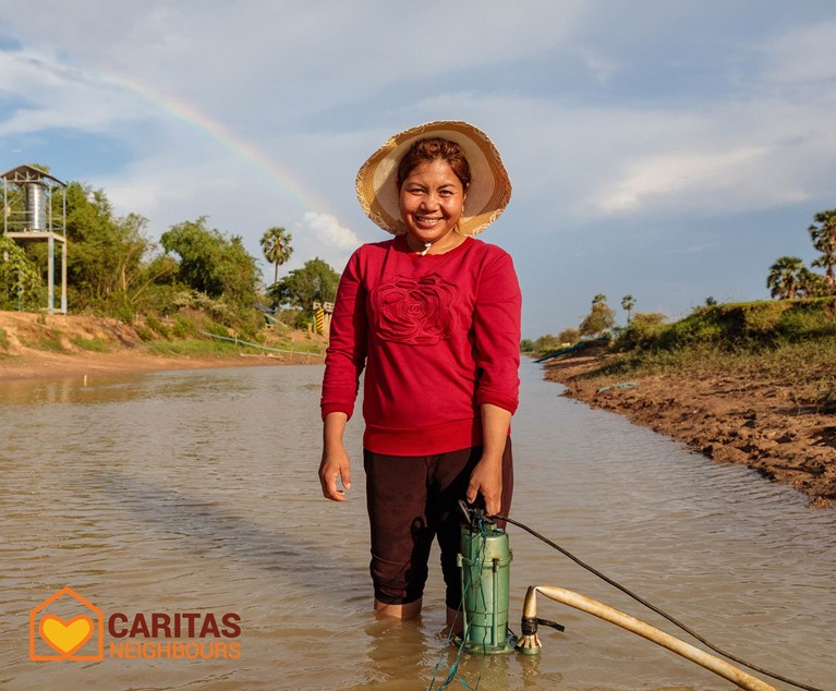 Phany adjusts her water pump in the canal outside her home in Western Cambodia. Photo credit: Richard Wainwright/Caritas Australia.