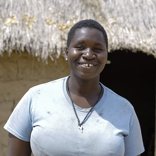 Maria smiling outside her home in Tanzania. Photo credit: August Lucky/Caritas Australia.