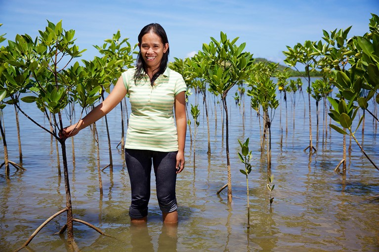 Aloma standing among mangroves in the Philippines. Photo credit: Richard Wainwright/Caritas Australia.