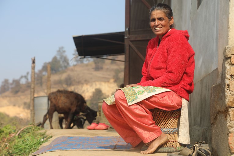 Sita sitting outside of her cow shed. Photo credit: Dipendra Lamsal/Caritas Australia.