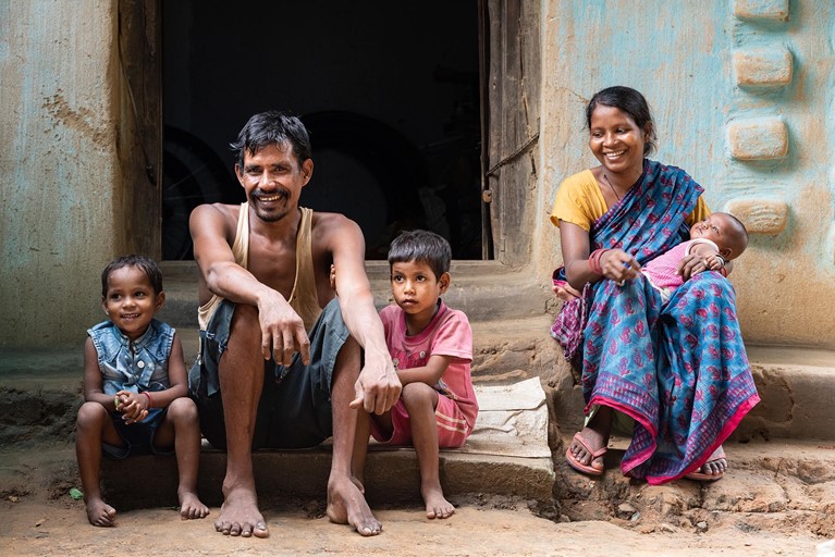 Biru and his wife Budhni sit with their children outside their house in their village in the state of Jharkhand, India. Photo: Sameer Bara/Caritas Australia