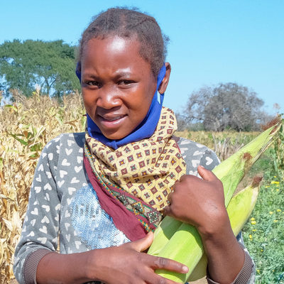 Anatercia carries corn next to her fields in Mozambique. Photo credit: Emidio Josine/Caritas Australia.